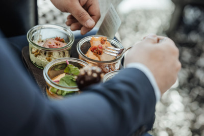 Person beim Lunch: Gerichte im Glas und Fingerfood
