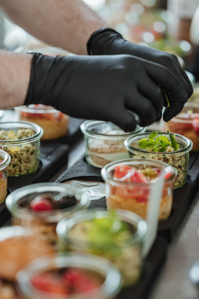 Chef preparing several savory dishes served in glasses.