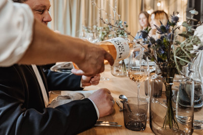 A server pours wine for a guest during dinner.