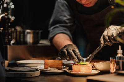 Koch richtet einen Teller bei einem Live-Cooking-Event an