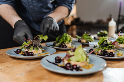 Koch bereitet mehrere Teller für das Catering vor